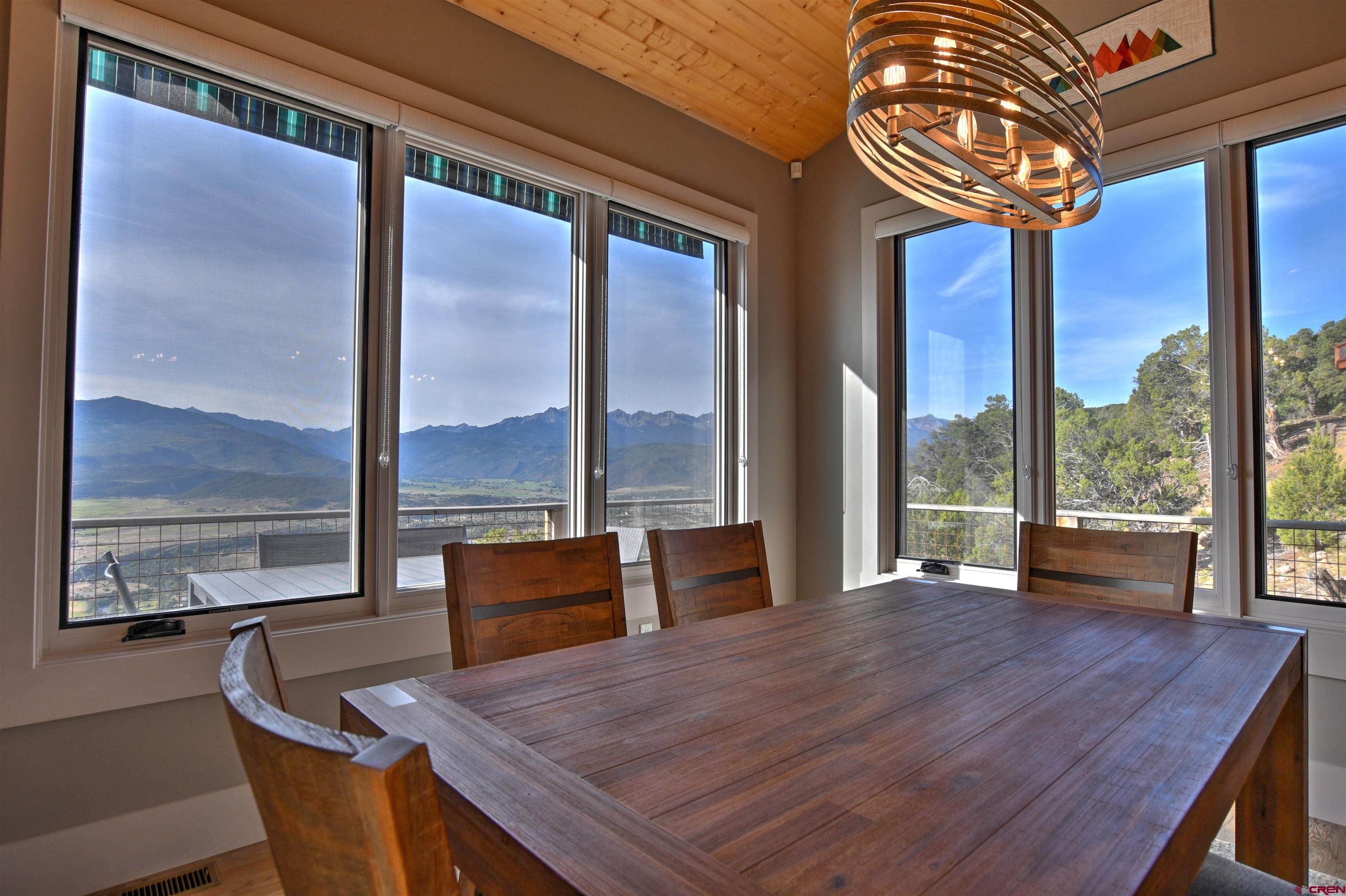 150 Enclave Road Ridgway, CO 81432 - Photo 7 of 45 a view of a dining room with furniture large windows and wooden floor