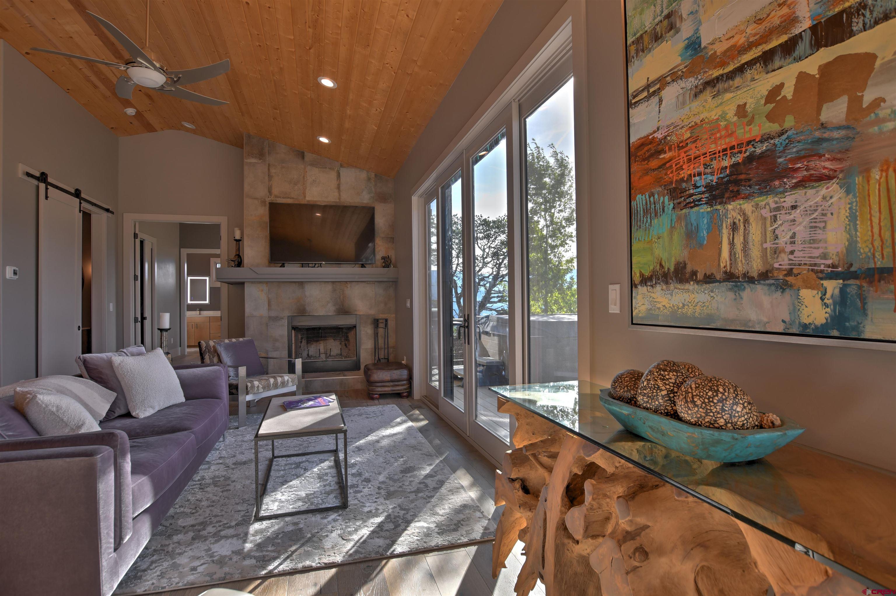 150 Enclave Road Ridgway, CO 81432 - Photo 8 of 45 a living room with furniture a flat screen tv and a fireplace