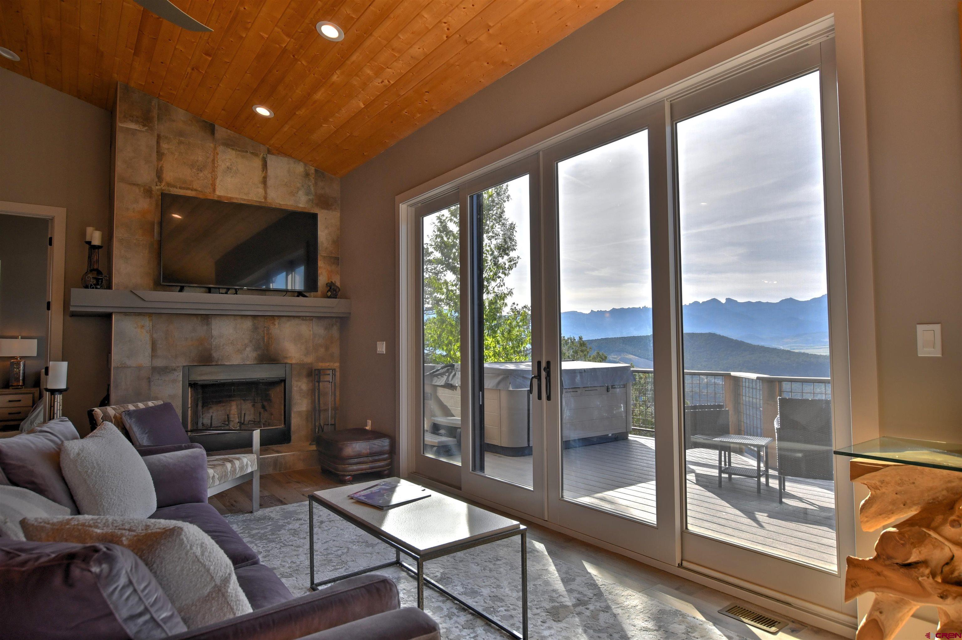 150 Enclave Road Ridgway, CO 81432 - Photo 9 of 45 a living room with furniture a flat screen tv and a fireplace