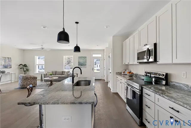 a kitchen with stainless steel appliances a sink stove and cabinets