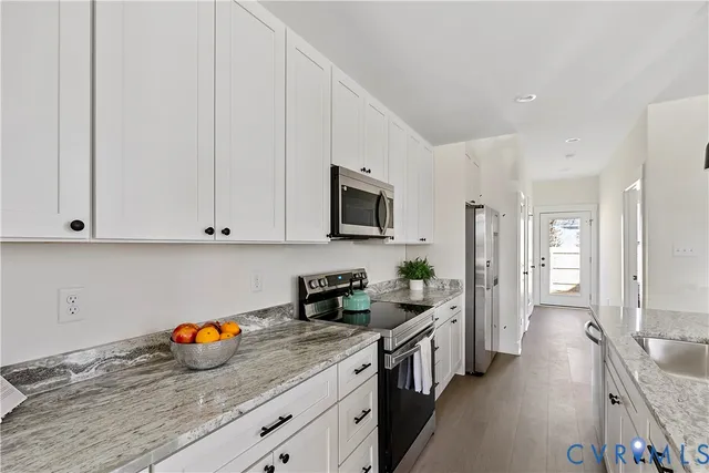 a kitchen with stainless steel appliances granite countertop a stove a sink and a refrigerator