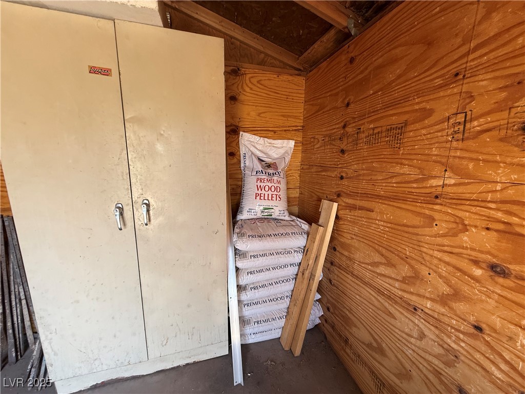 70 West Bonanza Road Las Vegas, NV 89124 - Photo 67 of 71 Unfurnished bedroom featuring vaulted ceiling, wood walls, and unfinished concrete flooring