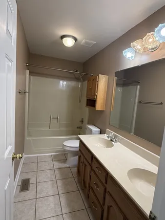 a bathroom with a sink a toilet a mirror and shower