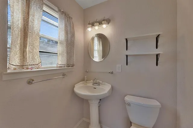 a bathroom with a toilet sink and mirror