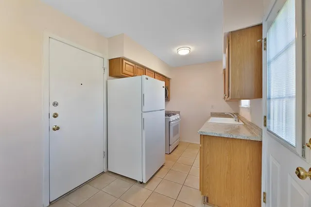 a bathroom with a granite countertop sink and a refrigerator