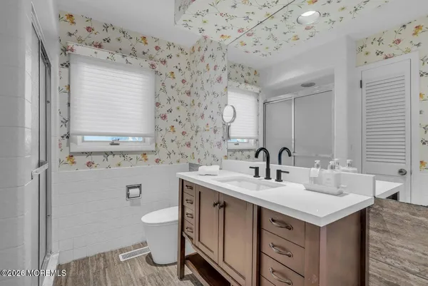 a bathroom with a sink a toilet and shower