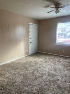 an empty room with windows and fan