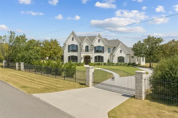 a view of a white house with a swimming pool and yard