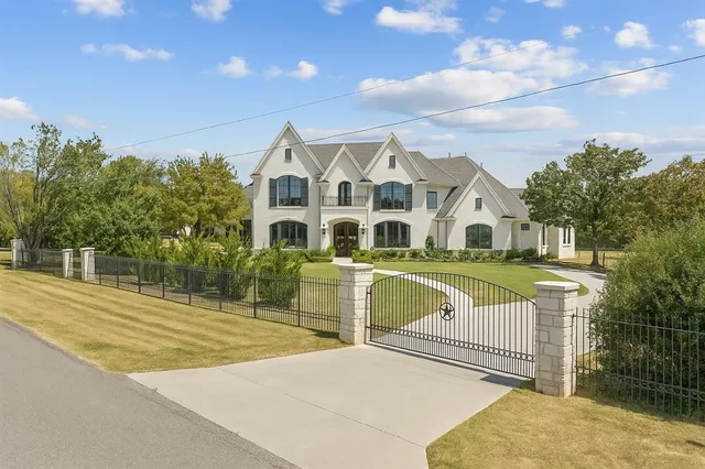 a view of a white house with a swimming pool and yard