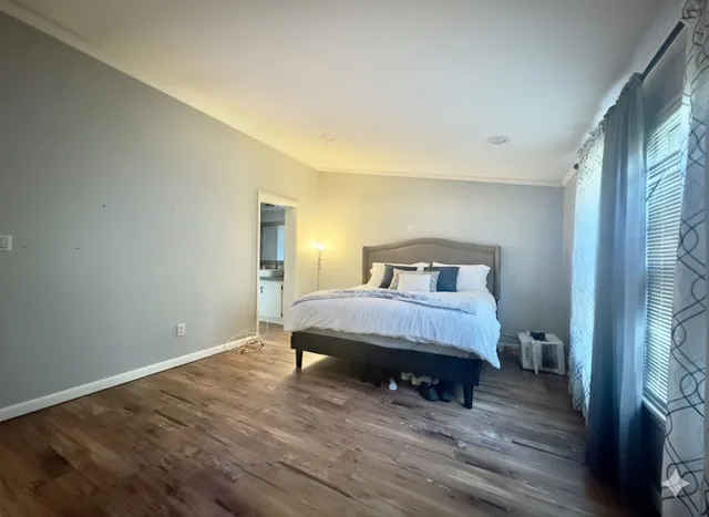 a bedroom with a bed and wooden floor