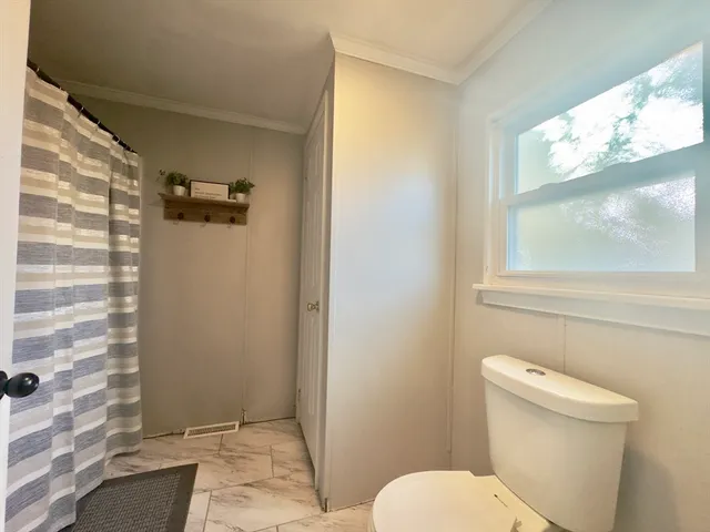 a bathroom with a toilet and a shower