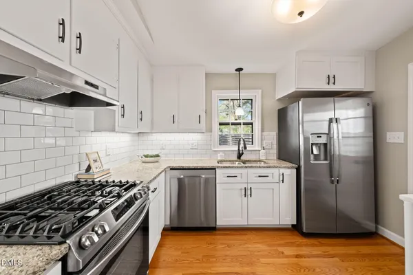 a kitchen with stainless steel appliances a stove a sink and a refrigerator