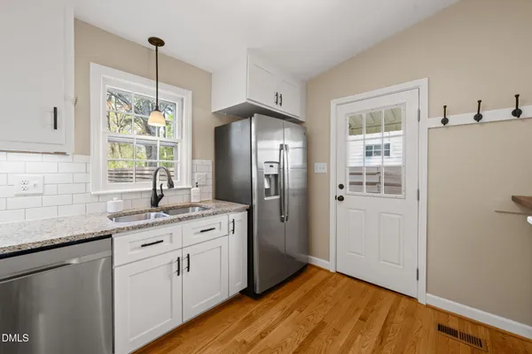 a kitchen with a refrigerator sink and cabinets