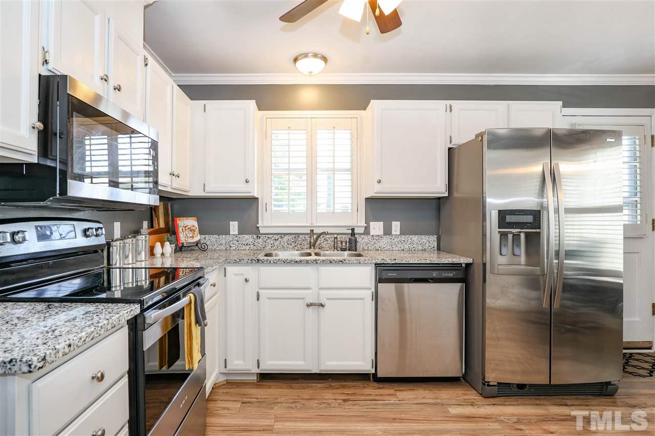 4841 Draper Road Raleigh, NC 27616 - Photo 11 of 30 a kitchen with stainless steel appliances granite countertop a stove a sink and a refrigerator