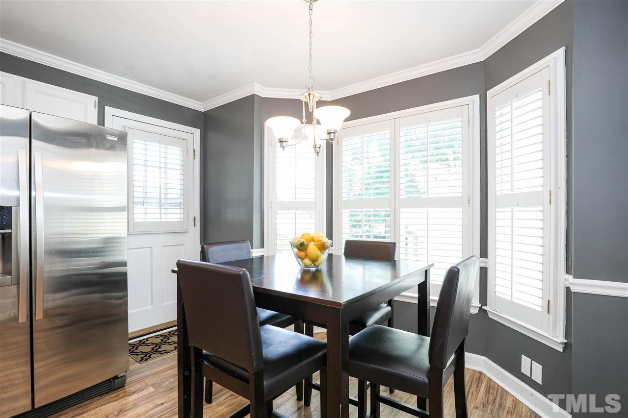 4841 Draper Road Raleigh, NC 27616 - Photo 13 of 30 a dining room with furniture a chandelier and wooden floor