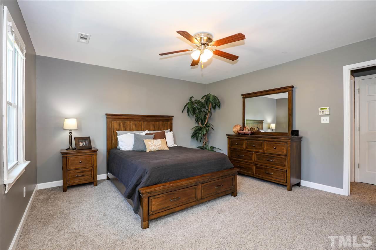 4841 Draper Road Raleigh, NC 27616 - Photo 16 of 30 a bedroom with a bed and a chandelier