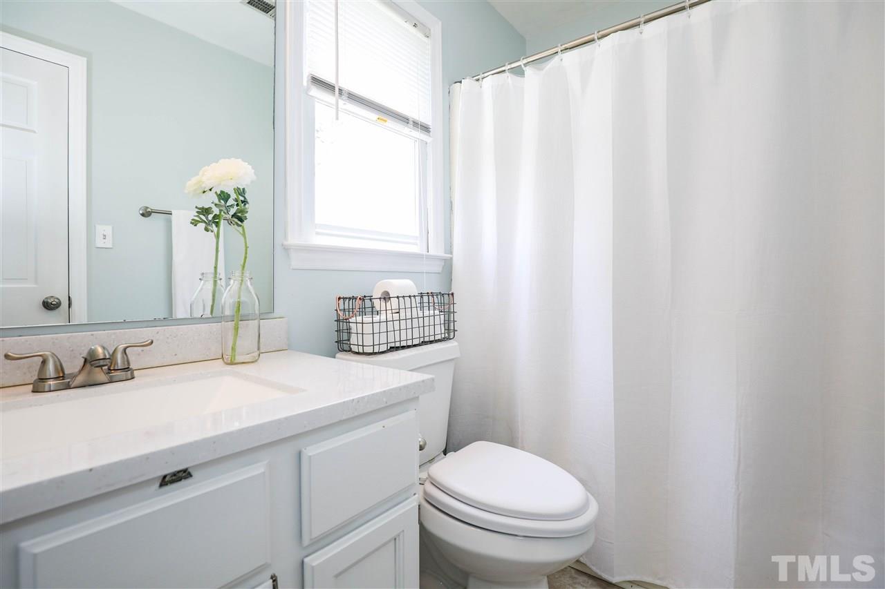 4841 Draper Road Raleigh, NC 27616 - Photo 21 of 30 a bathroom with a sink a toilet and a mirror