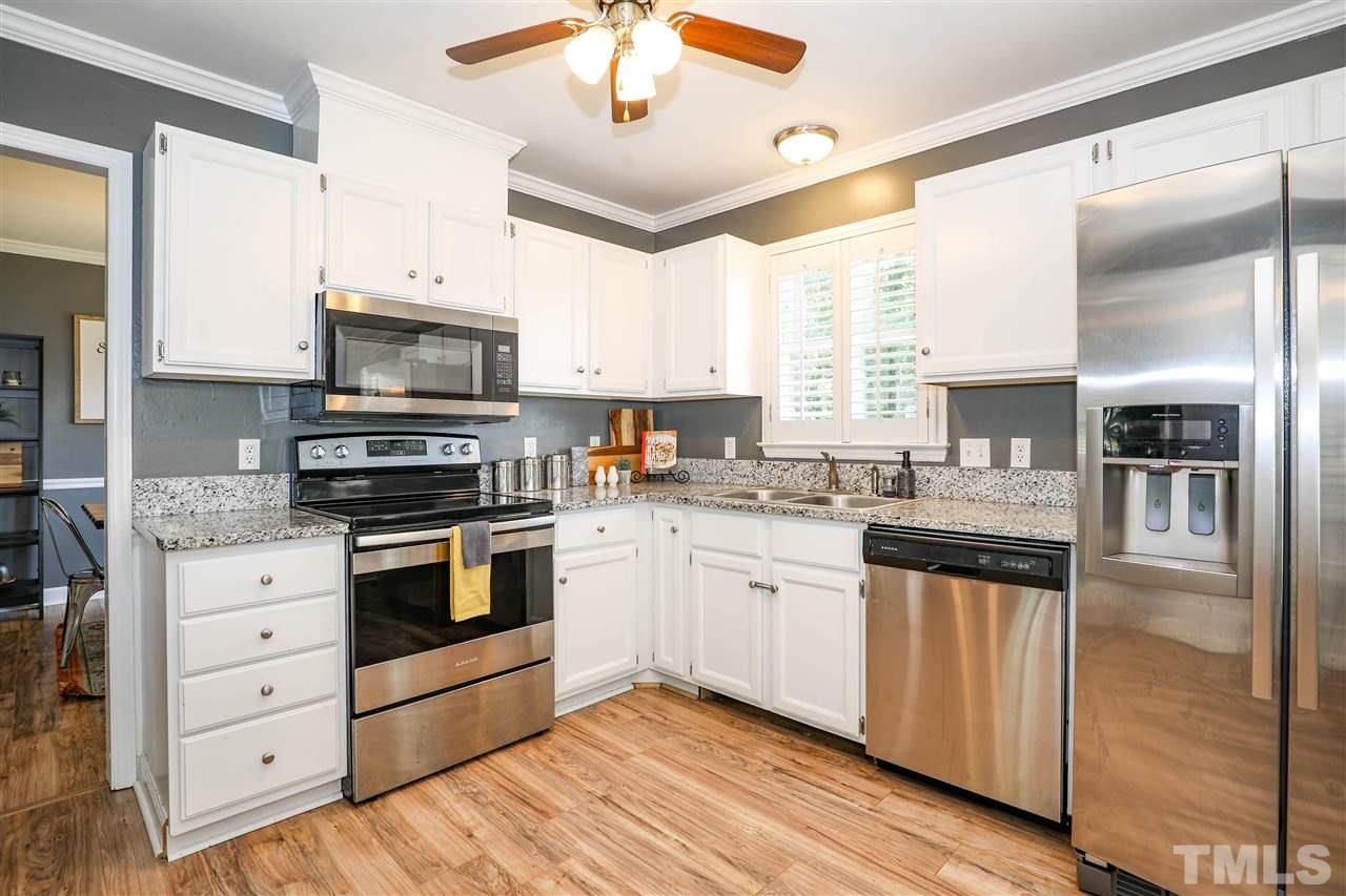 4841 Draper Road Raleigh, NC 27616 - Photo 9 of 30 a kitchen with granite countertop a refrigerator stove and microwave