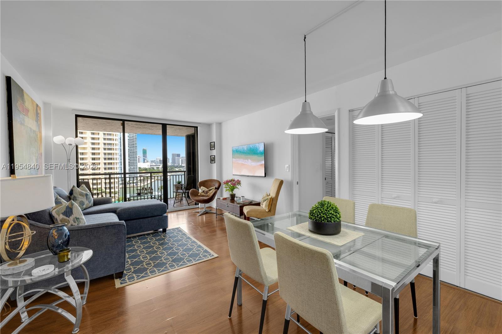 540 Brickell Key Drive, Unit 1514 Miami, FL 33131 - Photo 11 of 22 a dining room with furniture a chandelier and wooden floor