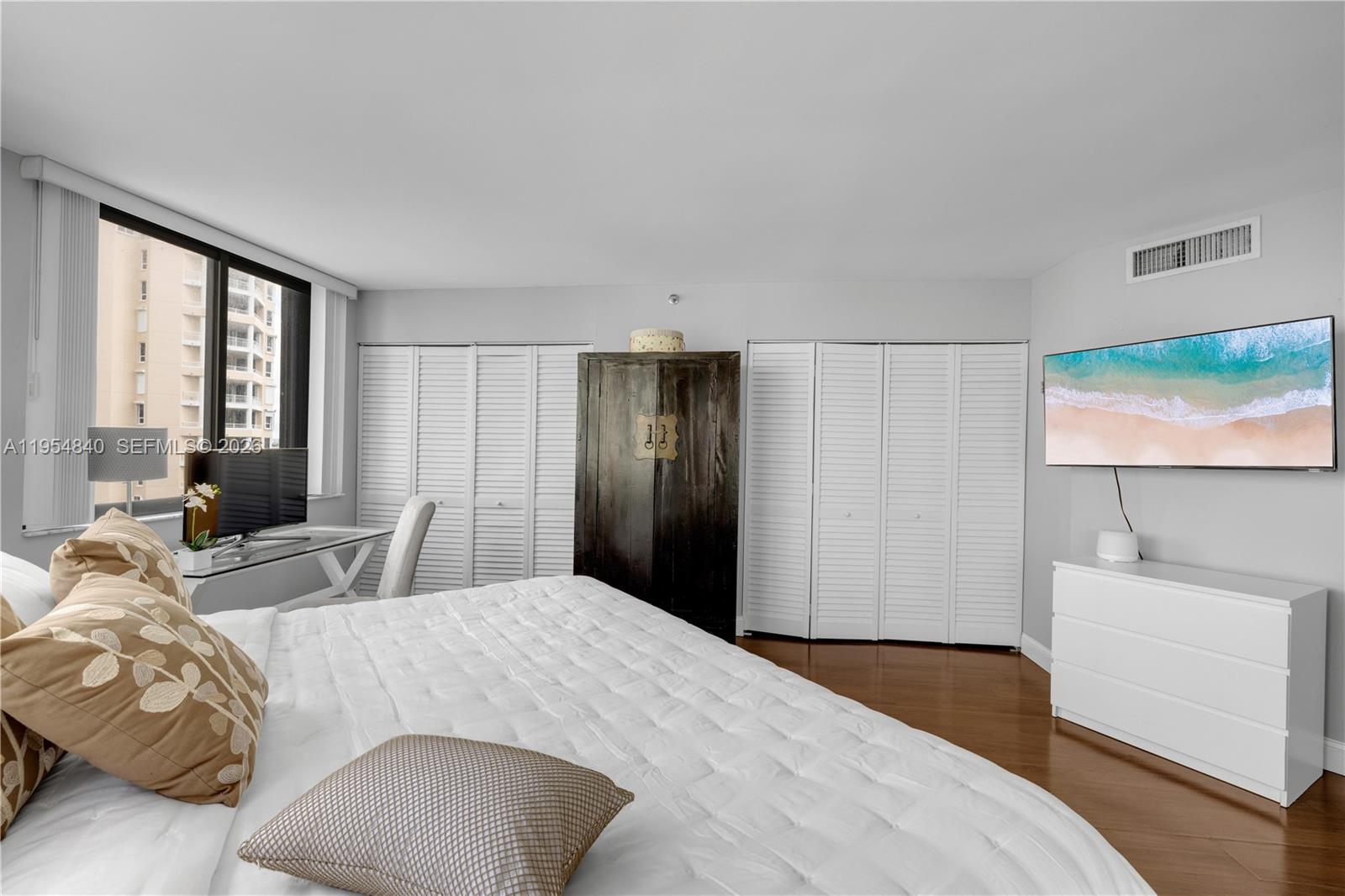 540 Brickell Key Drive, Unit 1514 Miami, FL 33131 - Photo 16 of 22 a bedroom with a bed a couch and large window