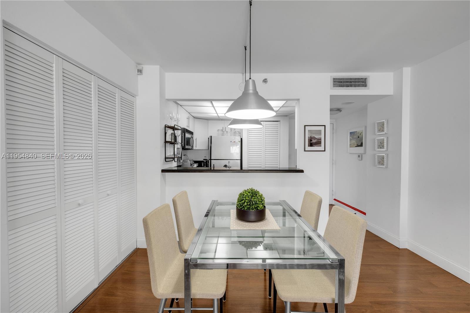 540 Brickell Key Drive, Unit 1514 Miami, FL 33131 - Photo 10 of 22 a view of a dining room with furniture and wooden floor