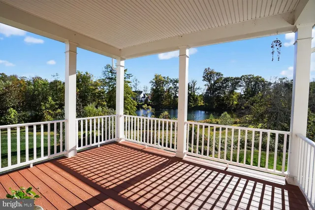 an empty room with wooden floor ceiling fan and windows