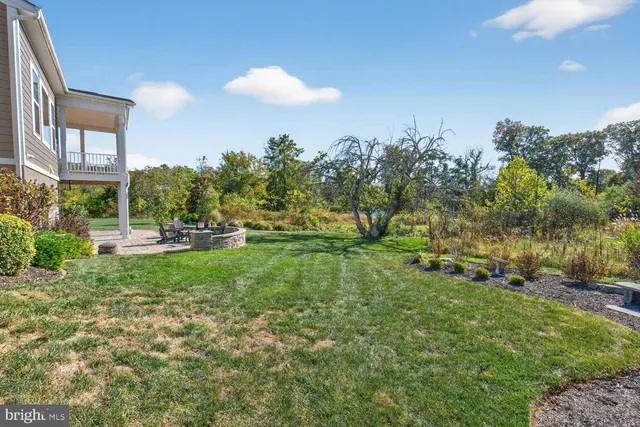 a front view of a house with a yard and tree