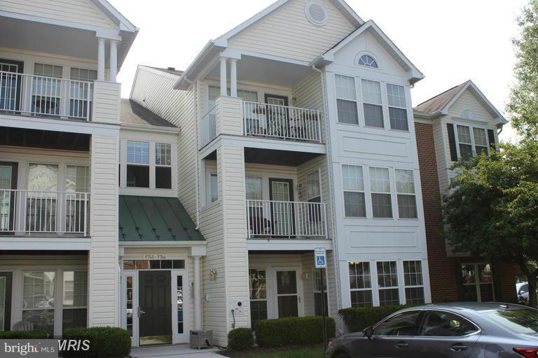 9765 Reese Farm Road, Unit L Owings Mills, MD 21117 - Photo 1 of 17 a front view of a residential apartment building with a yard
