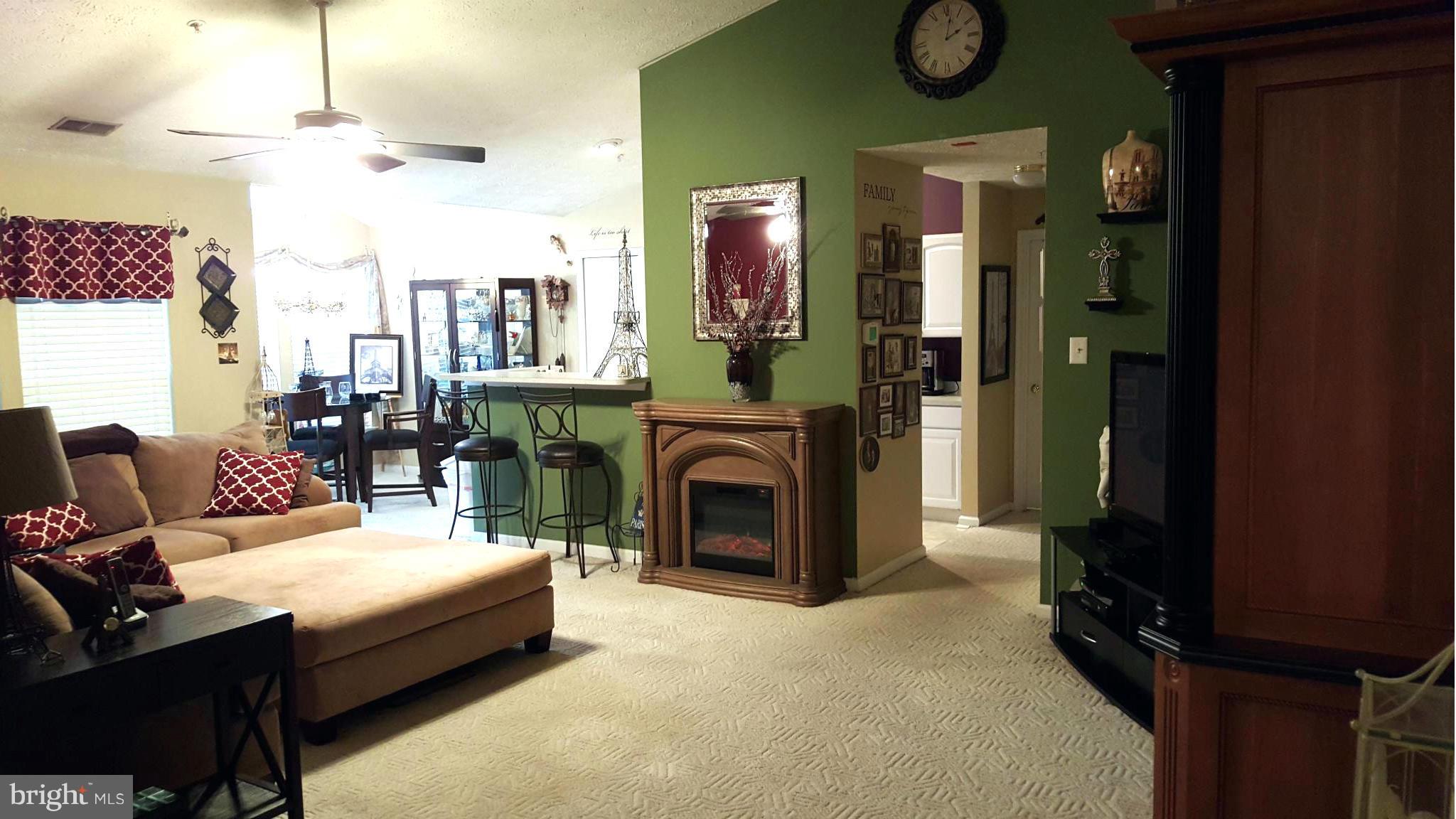 9765 Reese Farm Road, Unit L Owings Mills, MD 21117 - Photo 11 of 17 a living room with furniture a fireplace and a chandelier