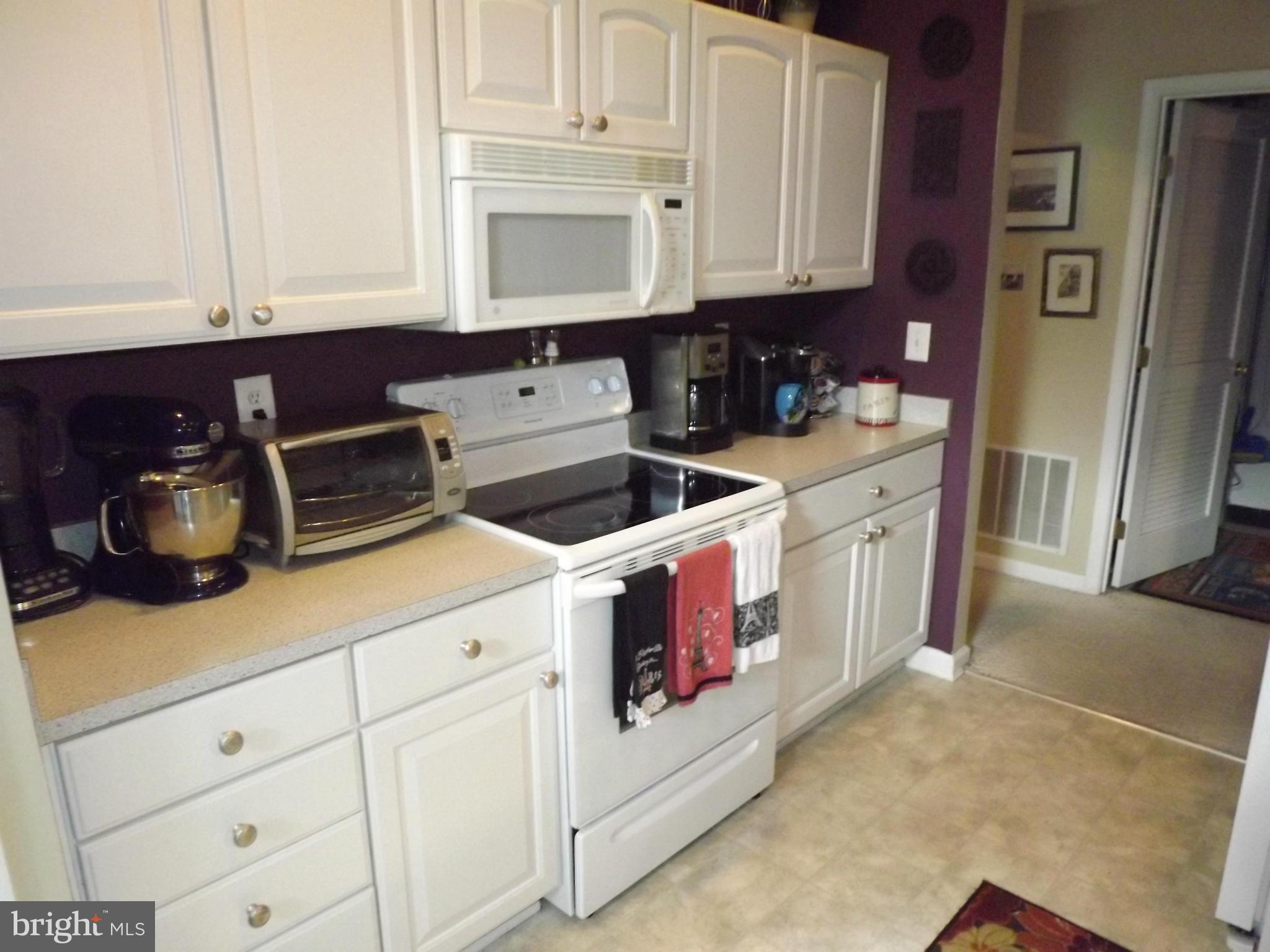 9765 Reese Farm Road, Unit L Owings Mills, MD 21117 - Photo 4 of 17 a kitchen with stainless steel appliances granite countertop white cabinets and a stove