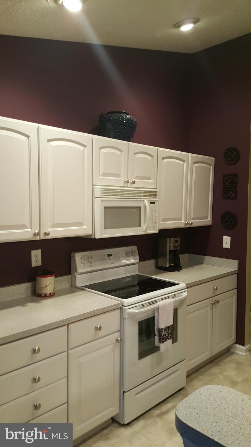 9765 Reese Farm Road, Unit L Owings Mills, MD 21117 - Photo 7 of 17 a kitchen with white cabinets and white appliances