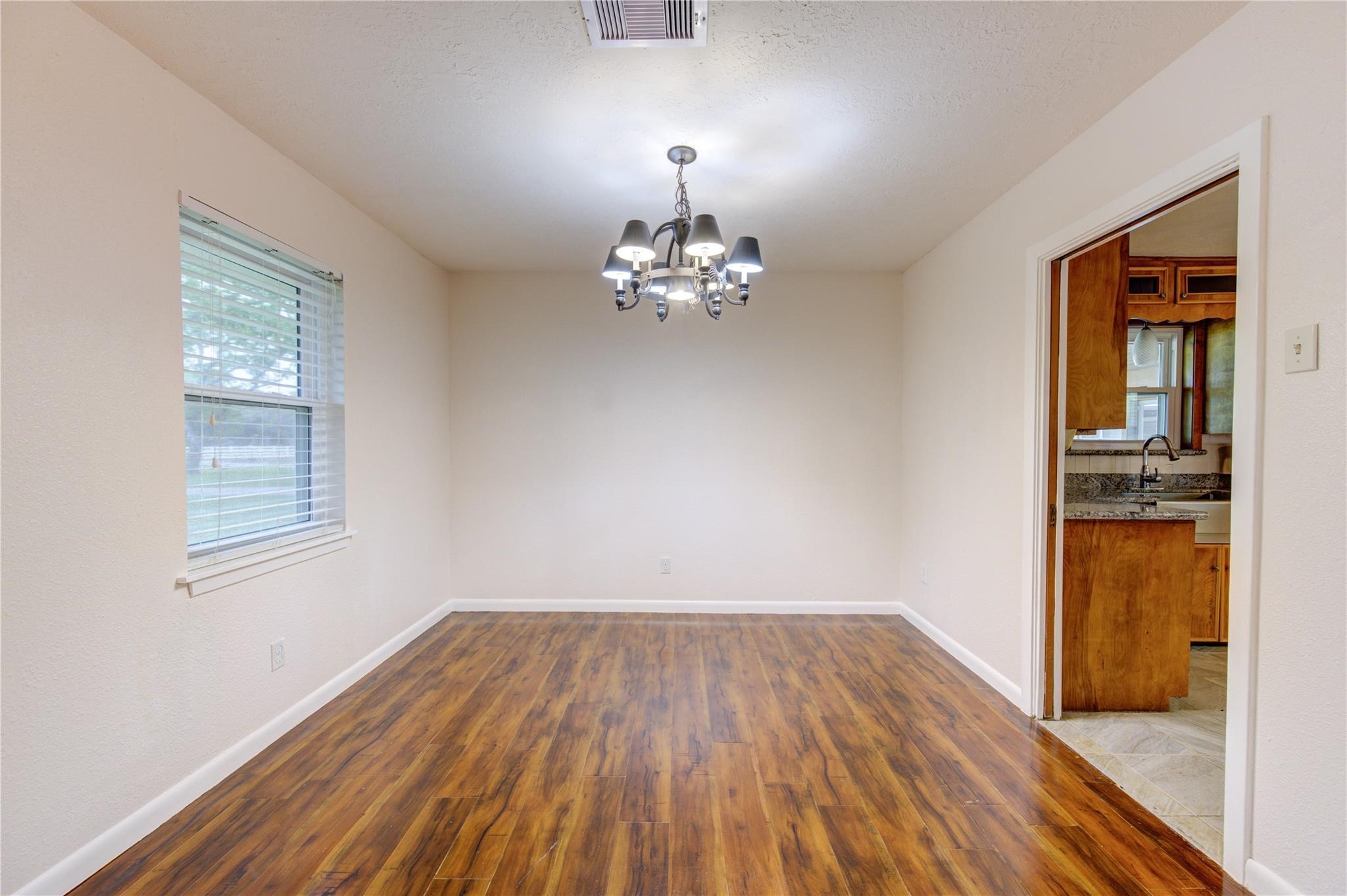 1745 Stone Road Pearland, TX 77581 - Photo 11 of 31 a view of a room with wooden floor a ceiling fan and windows