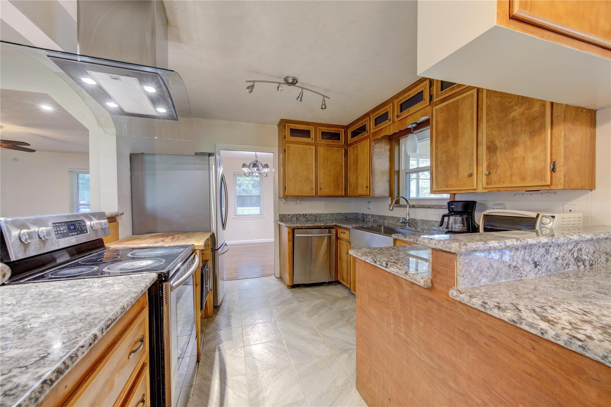 1745 Stone Road Pearland, TX 77581 - Photo 13 of 31 a kitchen with stainless steel appliances granite countertop a sink a stove top oven a counter space and cabinets