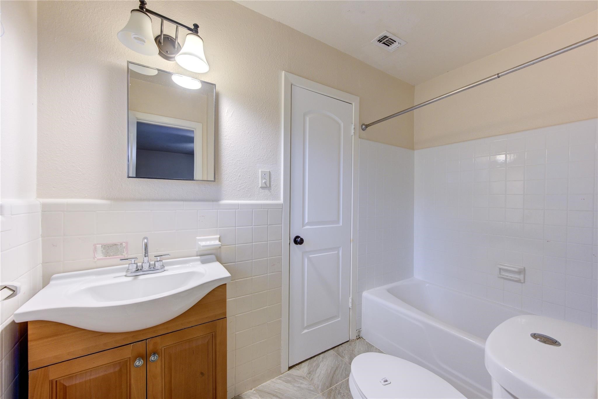 1745 Stone Road Pearland, TX 77581 - Photo 19 of 31 a bathroom with a sink toilet vanity and tub