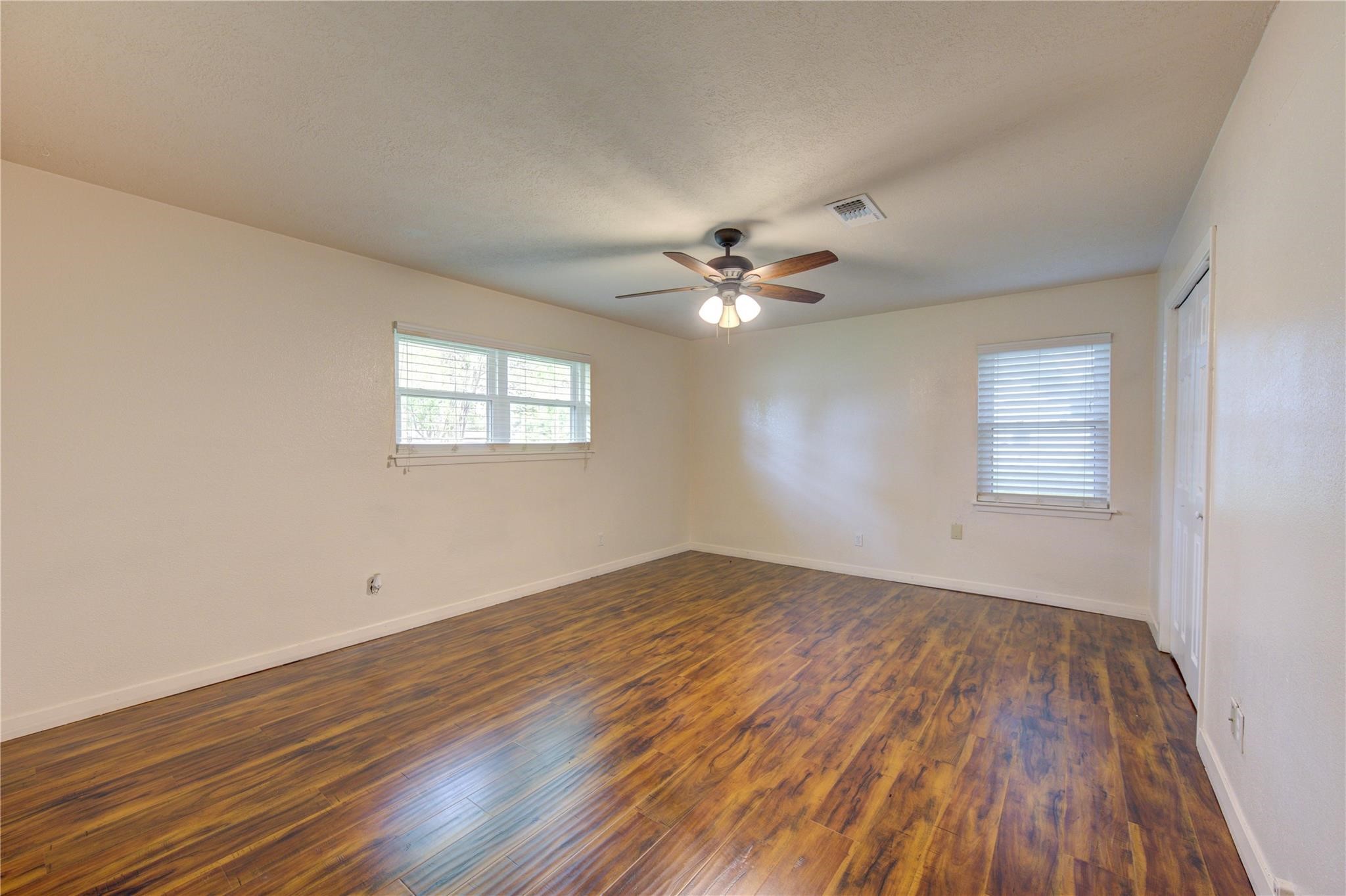 1745 Stone Road Pearland, TX 77581 - Photo 21 of 31 a view of an empty room with wooden floor and a window