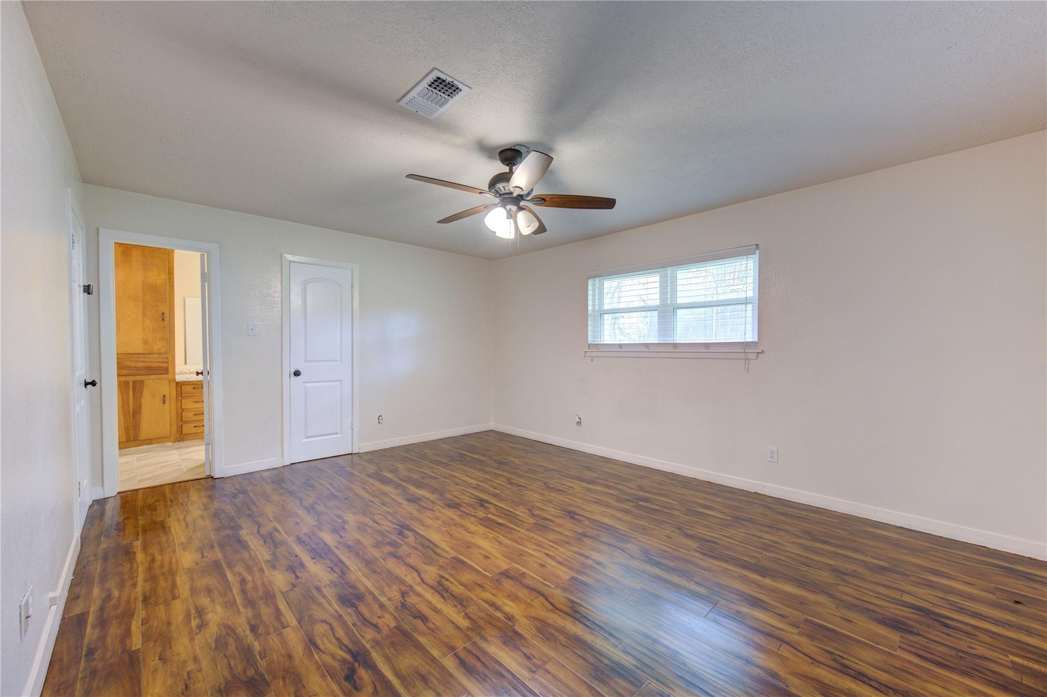 1745 Stone Road Pearland, TX 77581 - Photo 22 of 31 a view of a room with wooden floor and a ceiling fan