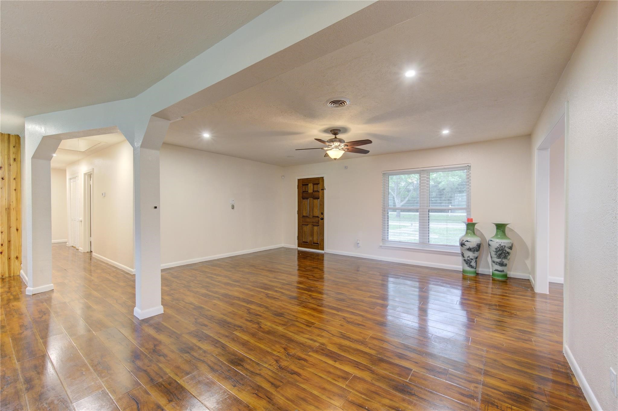 1745 Stone Road Pearland, TX 77581 - Photo 6 of 31 a view of an empty room with wooden floor and a window