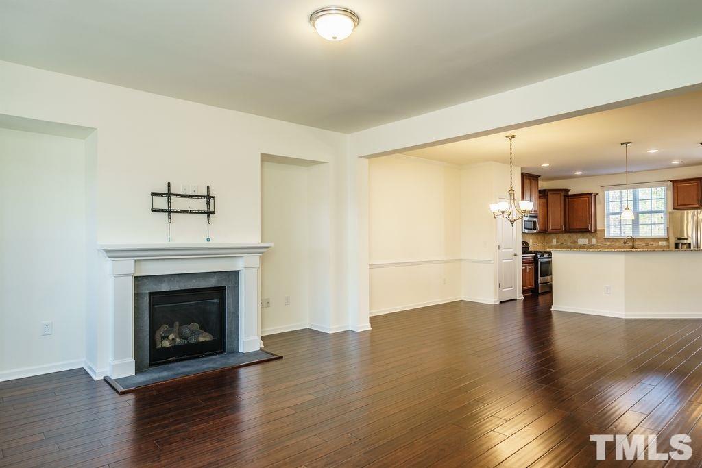 4956 Highcroft Drive Cary, NC 27519 - Photo 8 of 17 a view of an empty room with wooden floor and a fireplace