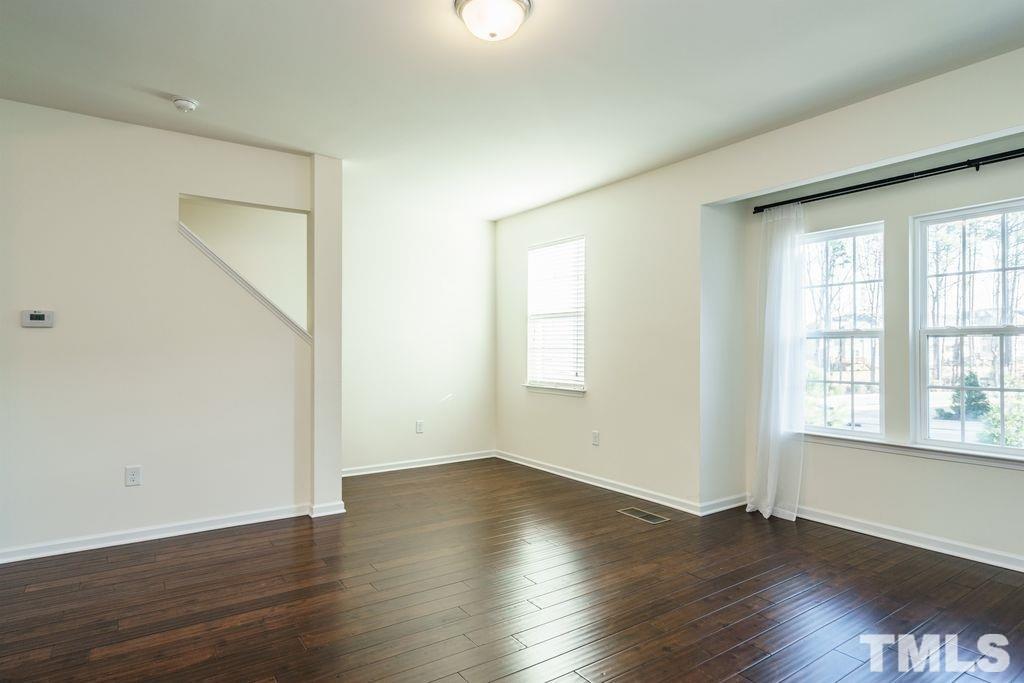 4956 Highcroft Drive Cary, NC 27519 - Photo 9 of 17 an empty room with wooden floor and windows