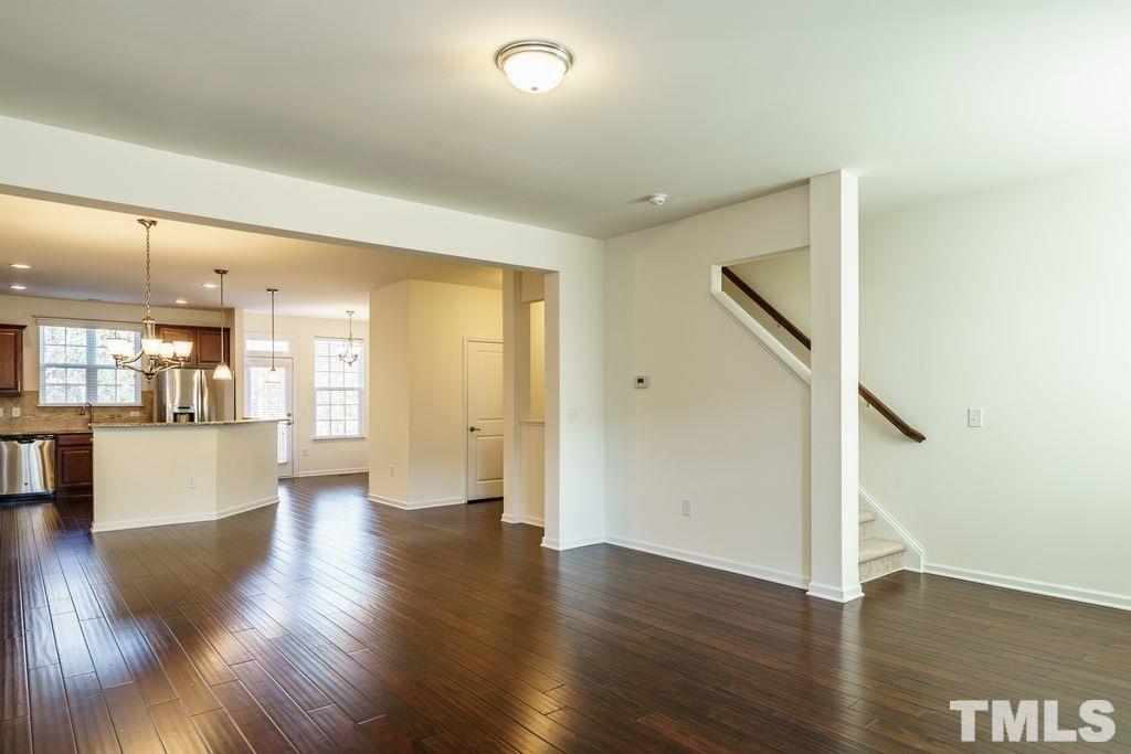 4956 Highcroft Drive Cary, NC 27519 - Photo 10 of 17 a view of an empty room with wooden floor and a kitchen