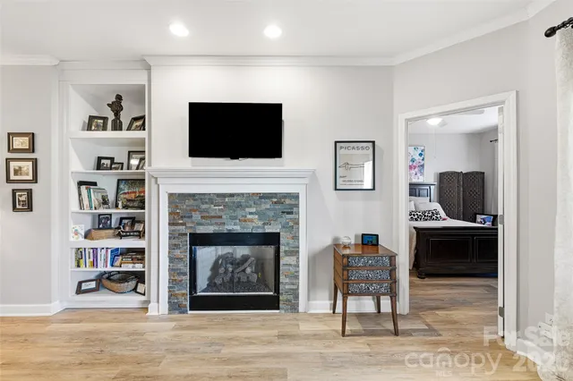 a living room with furniture a flat screen tv and a fireplace