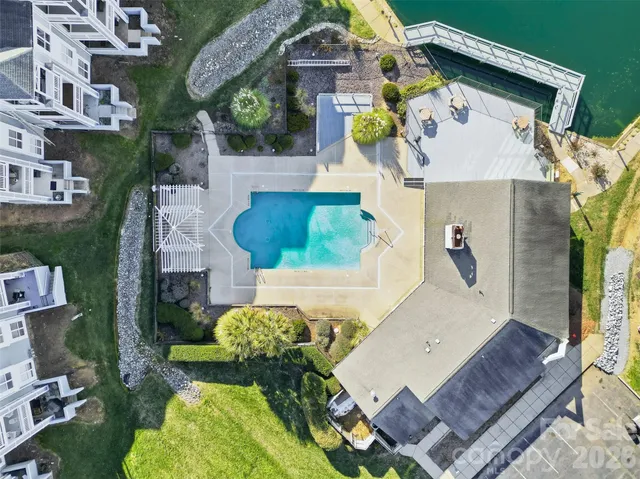 an aerial view of a house with swimming pool and large trees