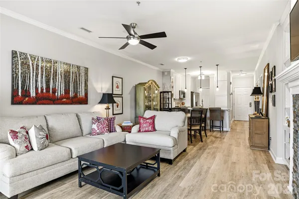 a living room with furniture and a view of kitchen