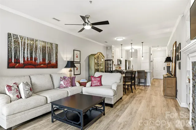 a living room with furniture and a view of kitchen