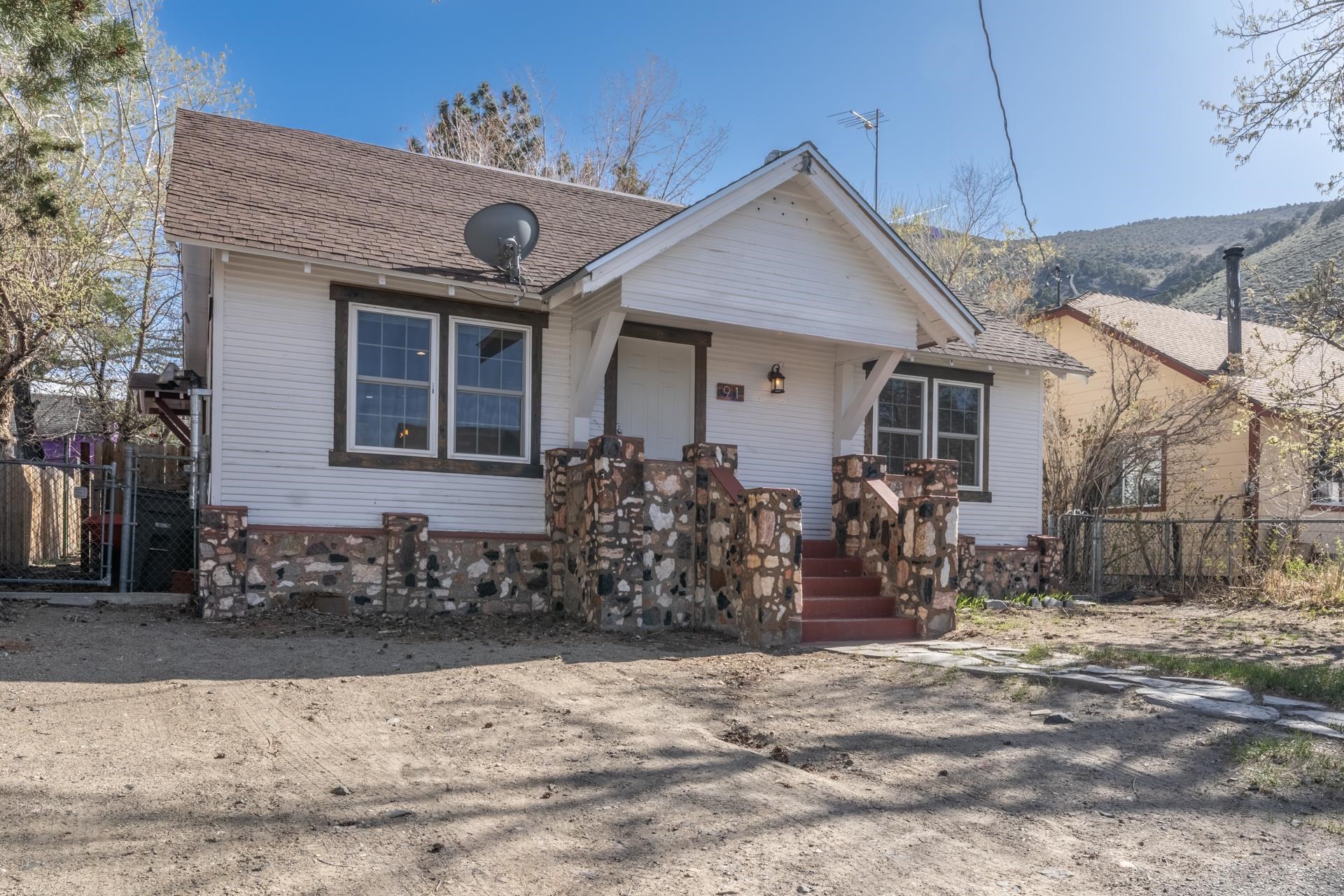 a couple of table and chairs in front of house