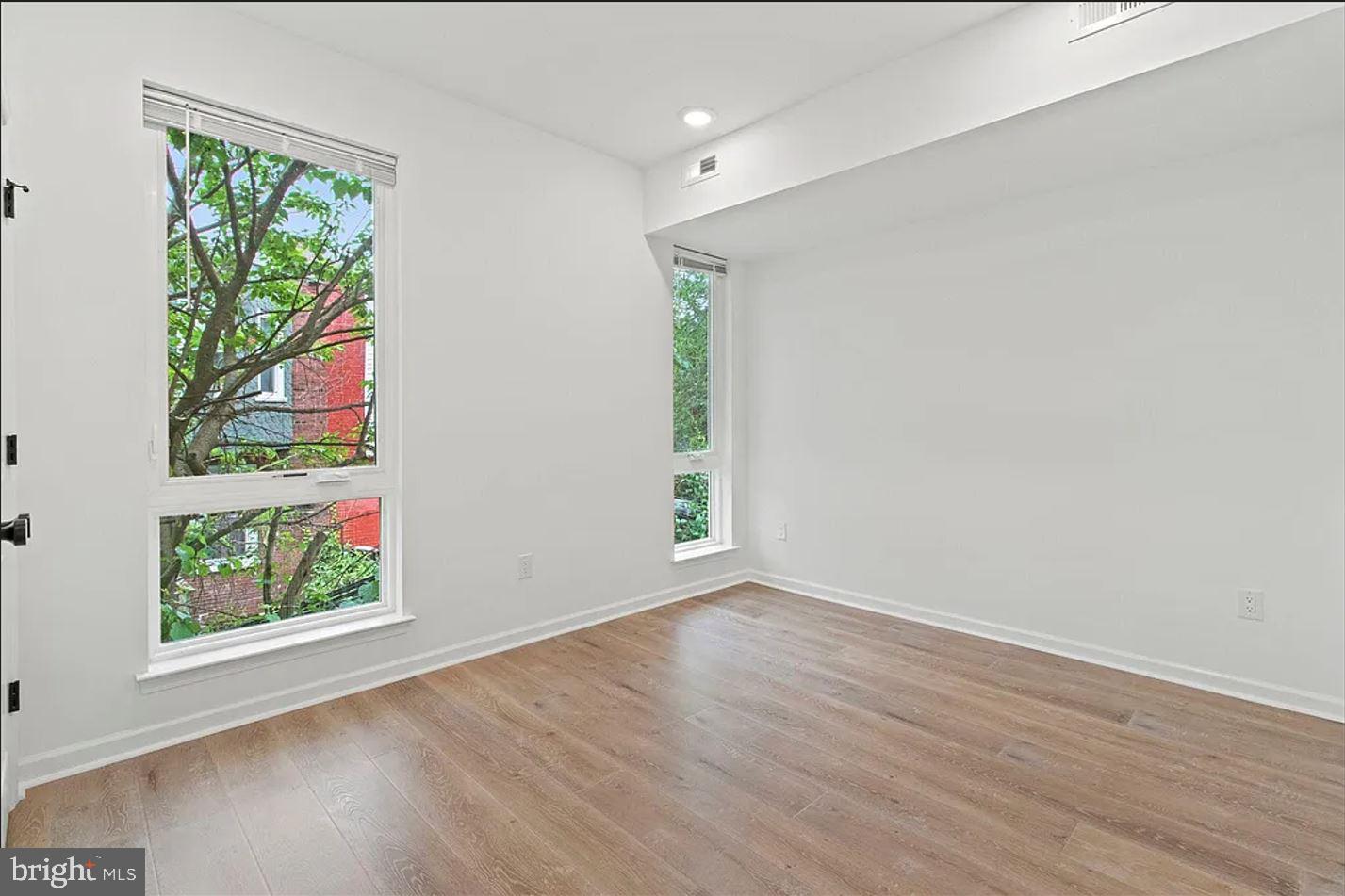 5225 Walnut Street, Unit 4 Philadelphia, PA 19139 - Photo 5 of 11 a view of an empty room with wooden floor and a window