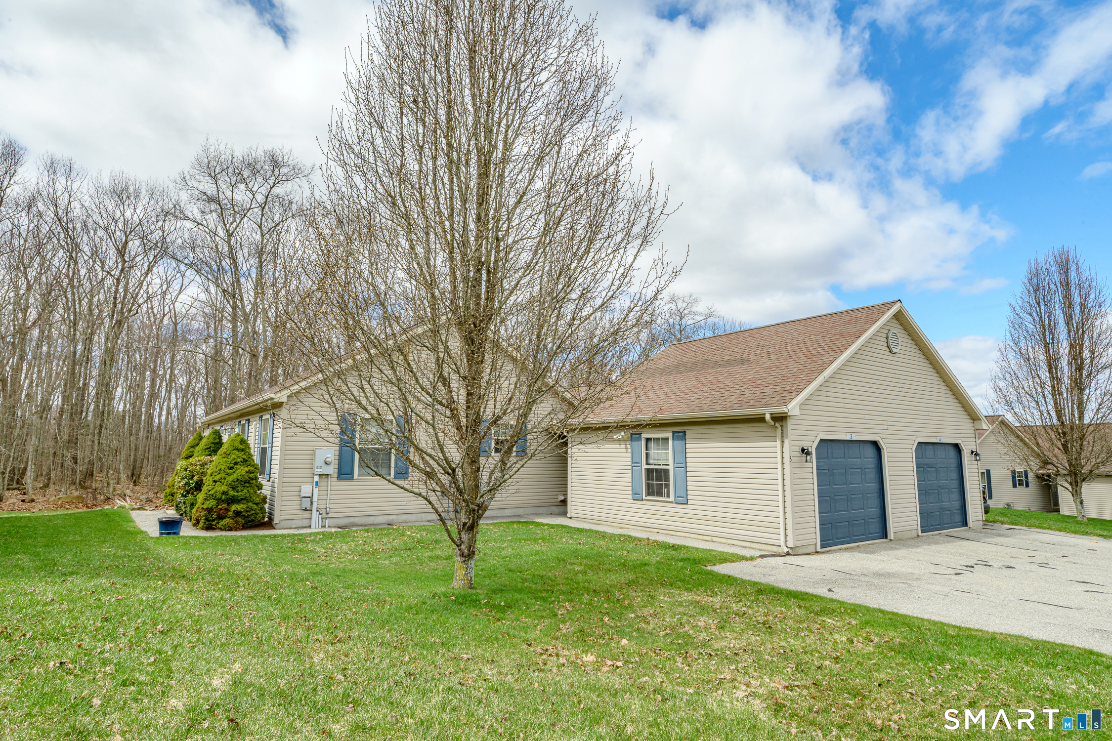 a view of a yard in front of a house with large trees