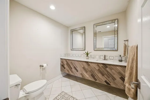 a bathroom with a granite countertop sink mirror and a toilet