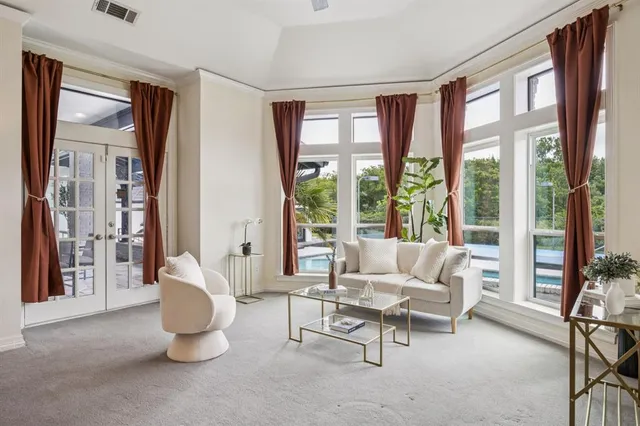 a living room with furniture and floor to ceiling windows