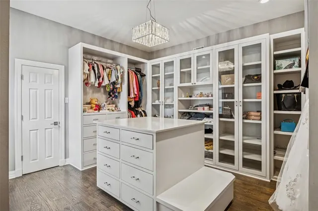 a view of walk in closet with clothes and shoes